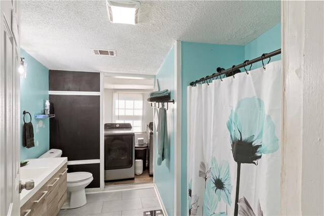 bathroom featuring tile patterned floors, visible vents, toilet, a shower with shower curtain, and washer / dryer