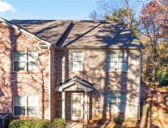 view of front of home featuring brick siding and central AC unit