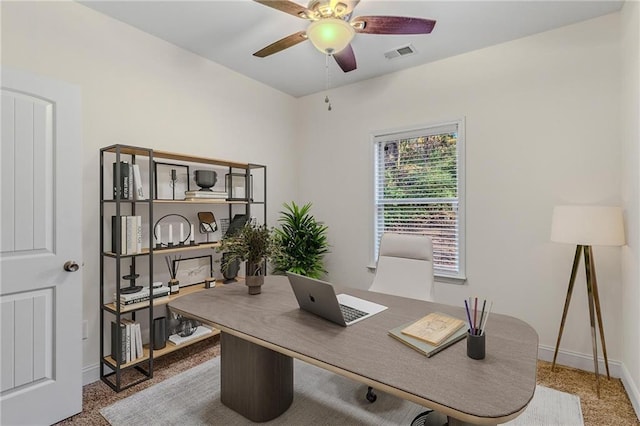 office space featuring baseboards, visible vents, and ceiling fan