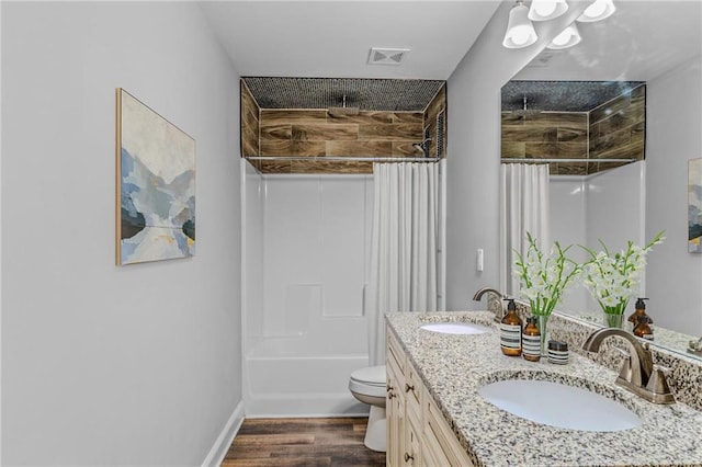 full bathroom featuring double vanity, toilet, wood finished floors, and a sink