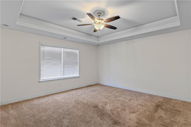 unfurnished room with a tray ceiling, visible vents, and crown molding