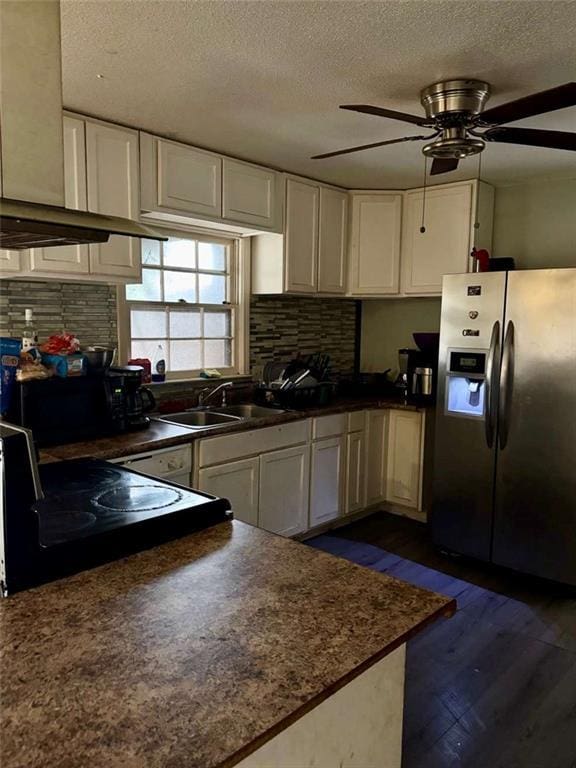 kitchen featuring a textured ceiling, white cabinetry, sink, electric stove, and stainless steel fridge