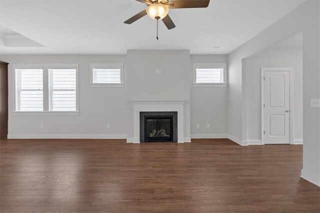 unfurnished living room with ceiling fan and dark wood-type flooring