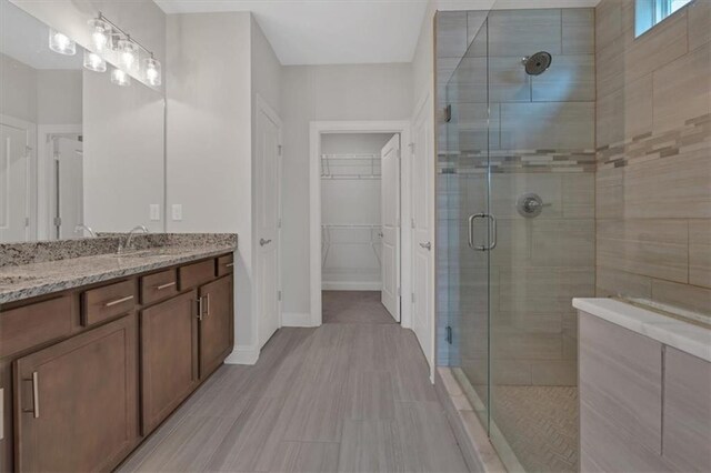 bathroom featuring walk in shower and vanity