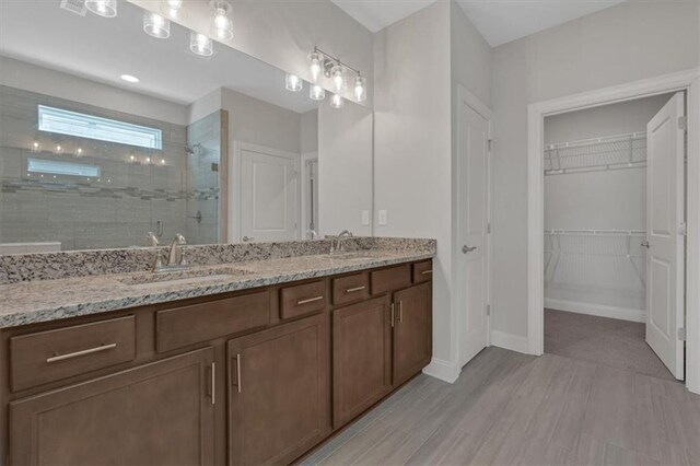 bathroom featuring a shower with door, vanity, and hardwood / wood-style flooring