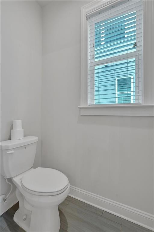 bathroom featuring wood-type flooring and toilet