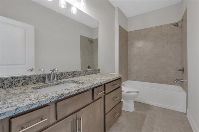 full bathroom featuring vanity, tiled shower / bath combo, toilet, and tile patterned floors