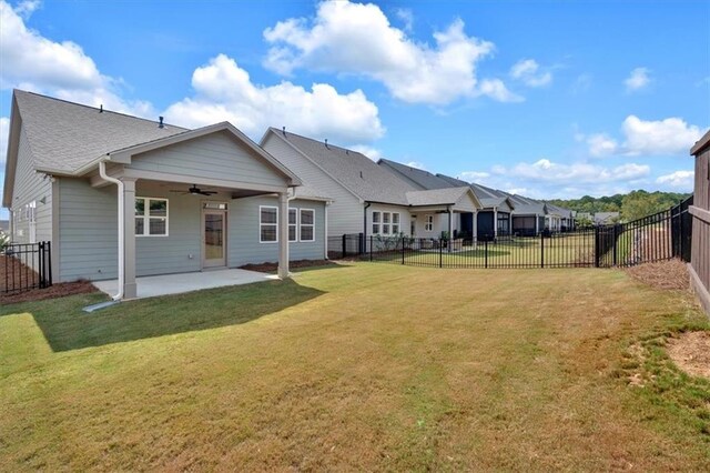 back of property featuring ceiling fan, a yard, and a patio