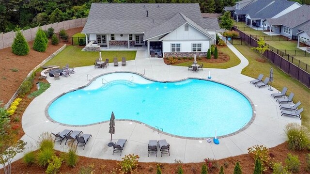 view of pool with a patio and a yard