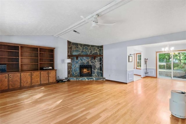1757 Mystery Cir SW, Conyers, GA 30094 - unfurnished living room featuring wood finished floors, a chandelier, a ceiling fan, a textured ceiling, and a stone fireplace