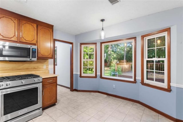 1757 Mystery Cir SW, Conyers, GA 30094 - kitchen with appliances with stainless steel finishes, brown cabinetry, light countertops, and baseboards