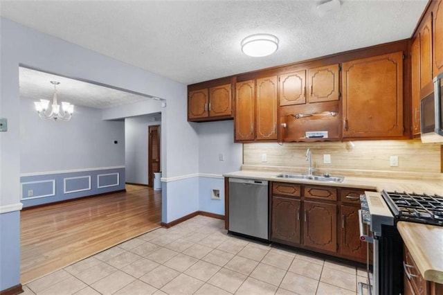 1757 Mystery Cir SW, Conyers, GA 30094 - kitchen with stainless steel appliances, a sink, light countertops, a chandelier, and tasteful backsplash