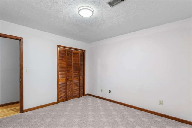 1757 Mystery Cir SW, Conyers, GA 30094 - unfurnished bedroom with a closet, a textured ceiling, carpet floors, and baseboards