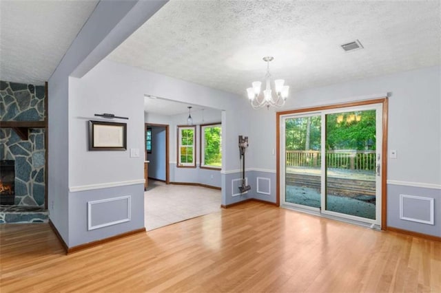 1757 Mystery Cir SW, Conyers, GA 30094 - unfurnished room featuring a chandelier, light wood-type flooring, healthy amount of natural light, a textured ceiling, and baseboards