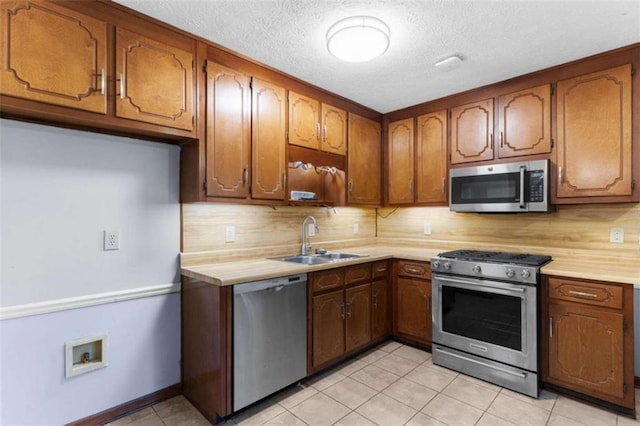 1757 Mystery Cir SW, Conyers, GA 30094 - kitchen with stainless steel appliances, a sink, light countertops, brown cabinetry, and a textured ceiling