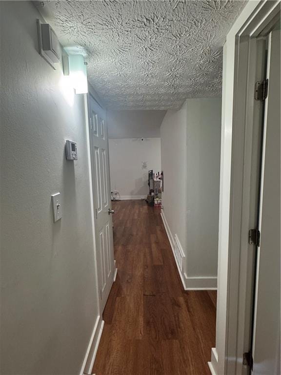 hallway featuring a textured ceiling and dark wood-type flooring