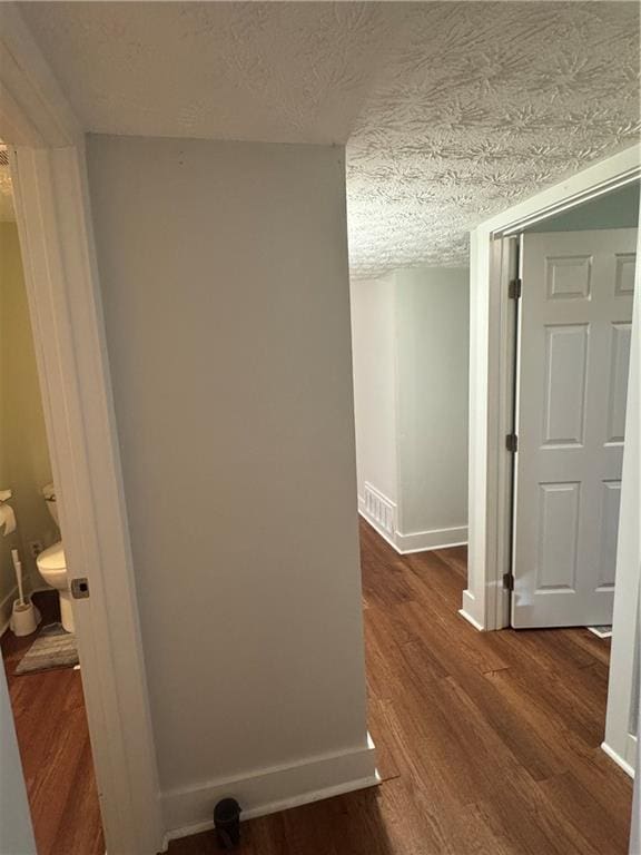 hallway featuring hardwood / wood-style floors and a textured ceiling