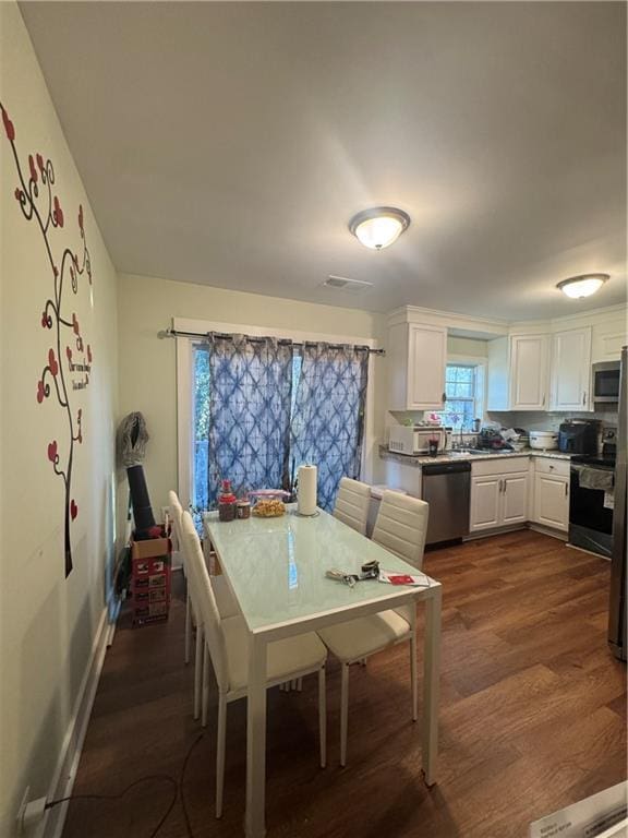 kitchen with white cabinets, dark hardwood / wood-style flooring, and stainless steel appliances