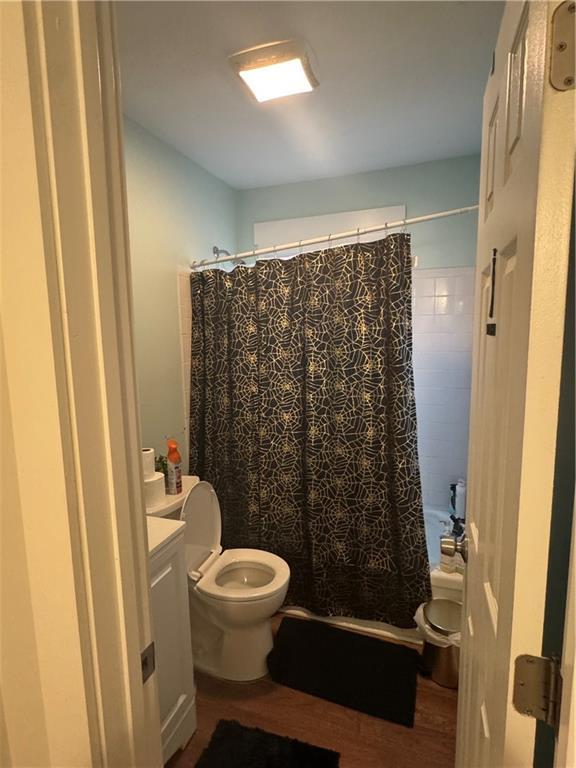 bathroom featuring wood-type flooring, vanity, and toilet