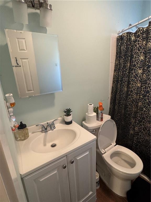 bathroom with vanity, toilet, and walk in shower