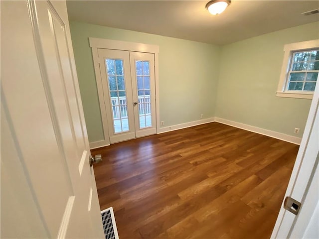 unfurnished room featuring dark hardwood / wood-style floors, a healthy amount of sunlight, and french doors