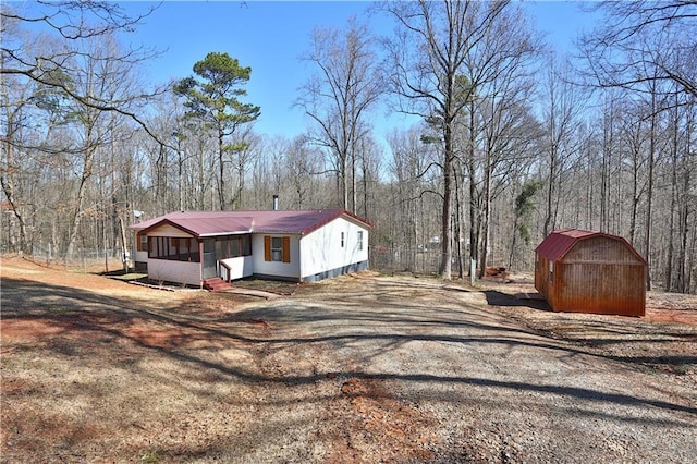 exterior space with a storage unit and a sunroom