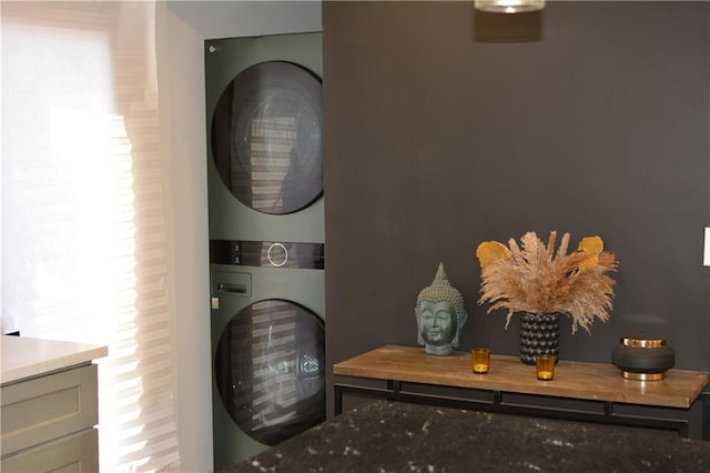 clothes washing area with stacked washer and dryer and laundry area