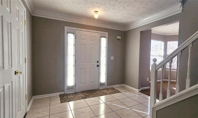 tiled entryway with crown molding and a textured ceiling