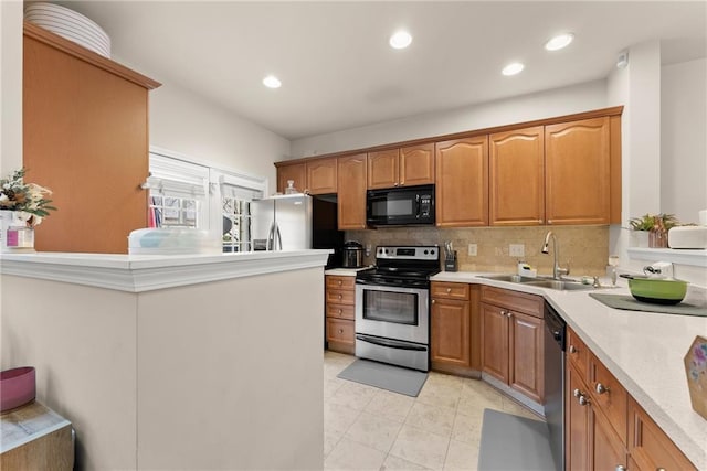 kitchen featuring recessed lighting, a sink, decorative backsplash, light countertops, and appliances with stainless steel finishes