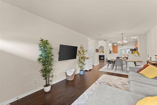 living area featuring a notable chandelier, baseboards, and wood finished floors