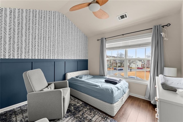 bedroom with a ceiling fan, wood finished floors, visible vents, baseboards, and lofted ceiling