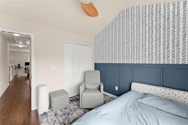 bedroom featuring a closet, a decorative wall, an accent wall, and wood finished floors