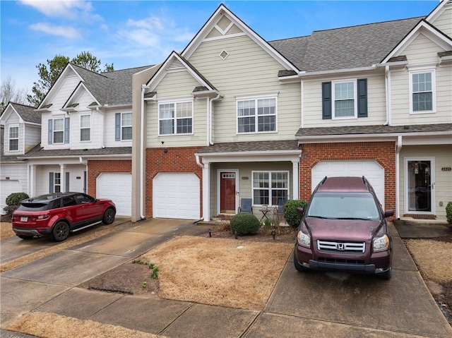 townhome / multi-family property featuring brick siding, an attached garage, driveway, and a shingled roof