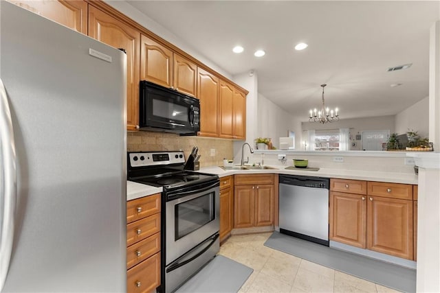 kitchen featuring visible vents, a sink, stainless steel appliances, light countertops, and backsplash