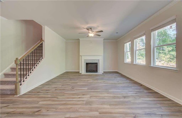 unfurnished living room featuring ornamental molding, ceiling fan, and light wood-type flooring