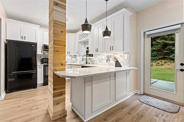 kitchen with white cabinetry, tasteful backsplash, pendant lighting, kitchen peninsula, and black appliances