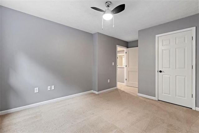 unfurnished bedroom with light colored carpet and ceiling fan