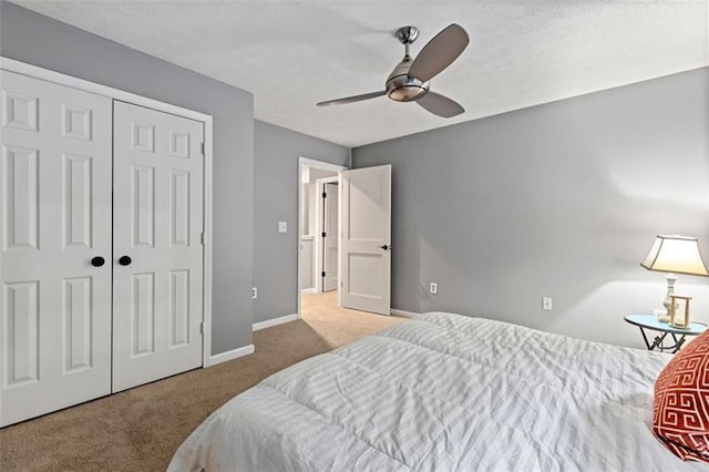 carpeted bedroom with ceiling fan and a closet