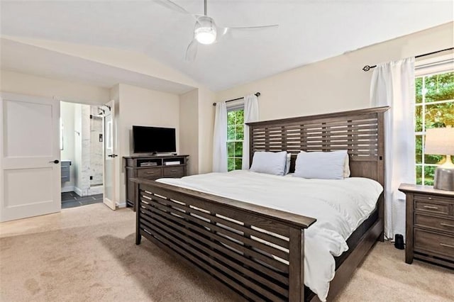 carpeted bedroom with lofted ceiling, connected bathroom, and ceiling fan