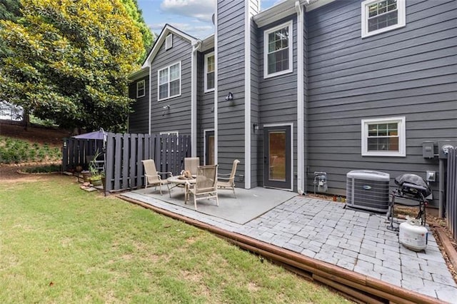 back of property with a lawn, central AC unit, and a patio