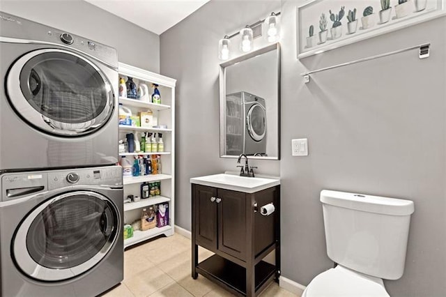 washroom with sink, light tile patterned flooring, and stacked washer / dryer