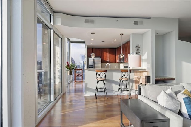 living area featuring plenty of natural light, wood finished floors, and visible vents