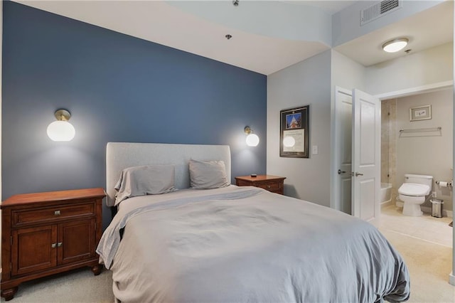 bedroom with visible vents, light colored carpet, and connected bathroom