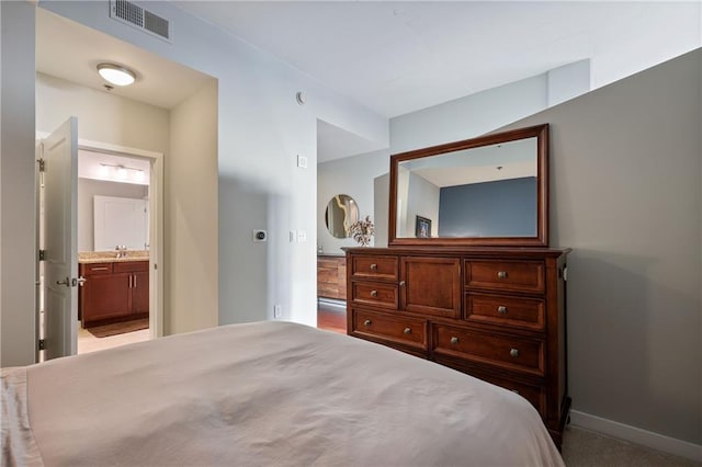 bedroom with a sink, visible vents, baseboards, and connected bathroom