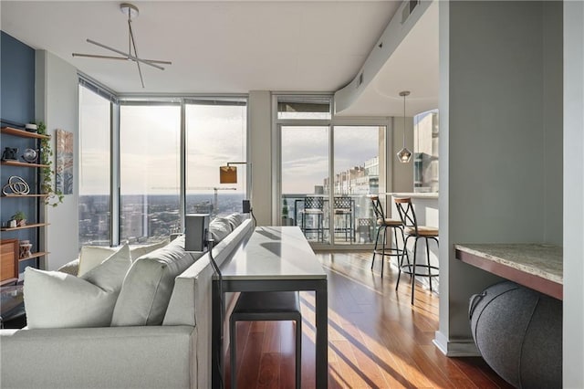 living area with floor to ceiling windows, wood finished floors, and visible vents