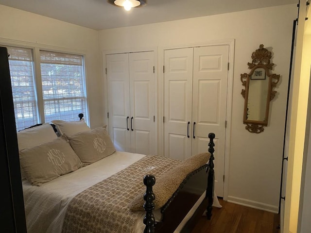 bedroom featuring two closets and dark wood-type flooring