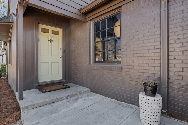 doorway to property featuring brick siding