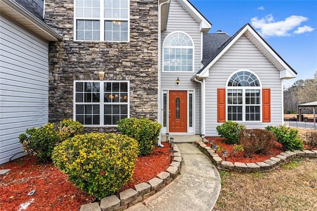 property entrance featuring stone siding