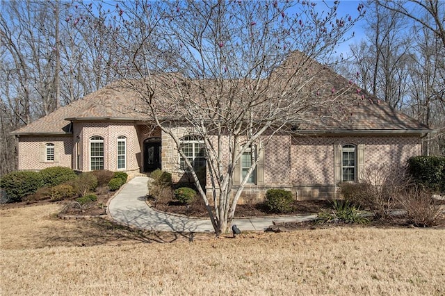 view of front facade featuring a front yard and brick siding