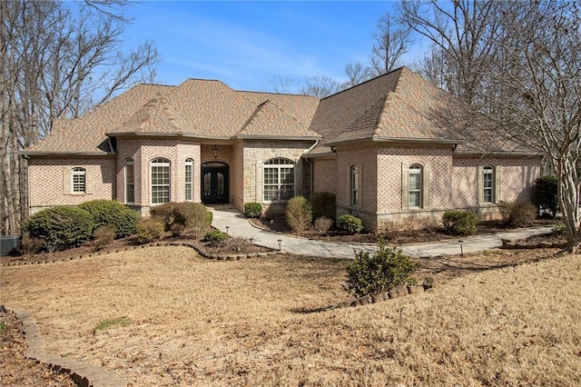 french provincial home with brick siding